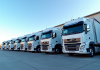 Plusieurs camions modernes de 44 tonnes garés dans un parking industriel lumineux
